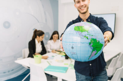 heureux-jeune-homme-affaires-detenant-globe-dans-bureau heureux-jeune-homme-affaires-detenant-globe-dans-bureau